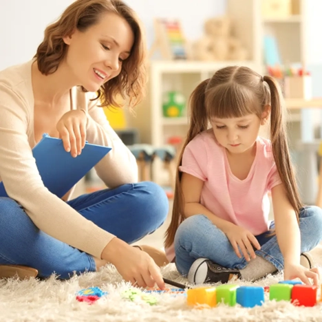 Teacher assisting child with autism spectrum disorder schools